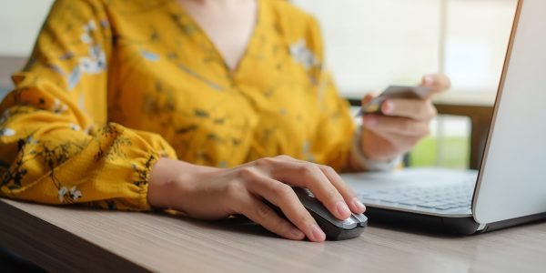 Asian woman holding credit card and using laptop for online shopping while making orders. internet, technology, ecommerce and online payment concept