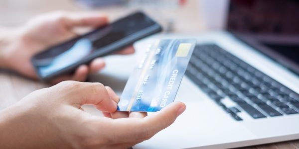 woman hand holding credit card with using smartphone and laptop for online shopping while making orders at home. business, lifestyle, technology, ecommerce, digital banking and online payment concept